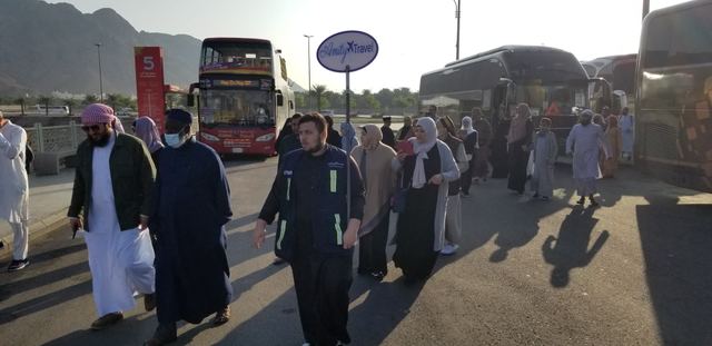 Amity group leader with the Amity Travel sign leading travelers to the group buses