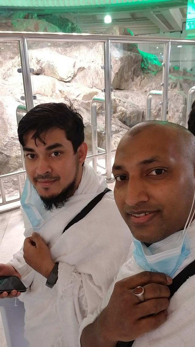 Two Amity travelers in ihram taking a selfie beside the rock of Mount Safa
