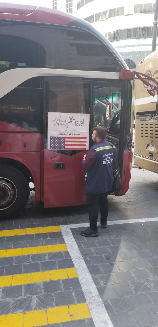 Amity staff member at the door of the Amity group bus with its Amity Travel sign